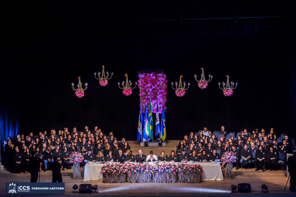 Colação de Grau da UFRPE. Imagem da mesa, presidida pela reitora. Conselheiros universitários vestidos com as becas