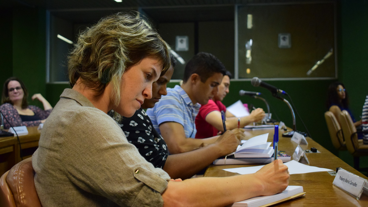 Imagem de pessoas estudando e escrevendo