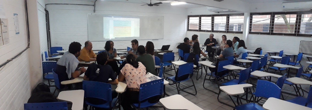 representantes da proplan e departamento de administração sentados em cadeiras numa sala de aula