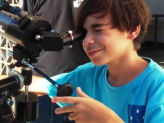 Foto de Bruno observando o céu por meio de telescópio do projeto da UFRPE