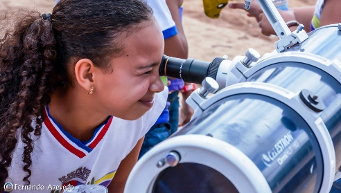 Aluna observando o céu no telescópio