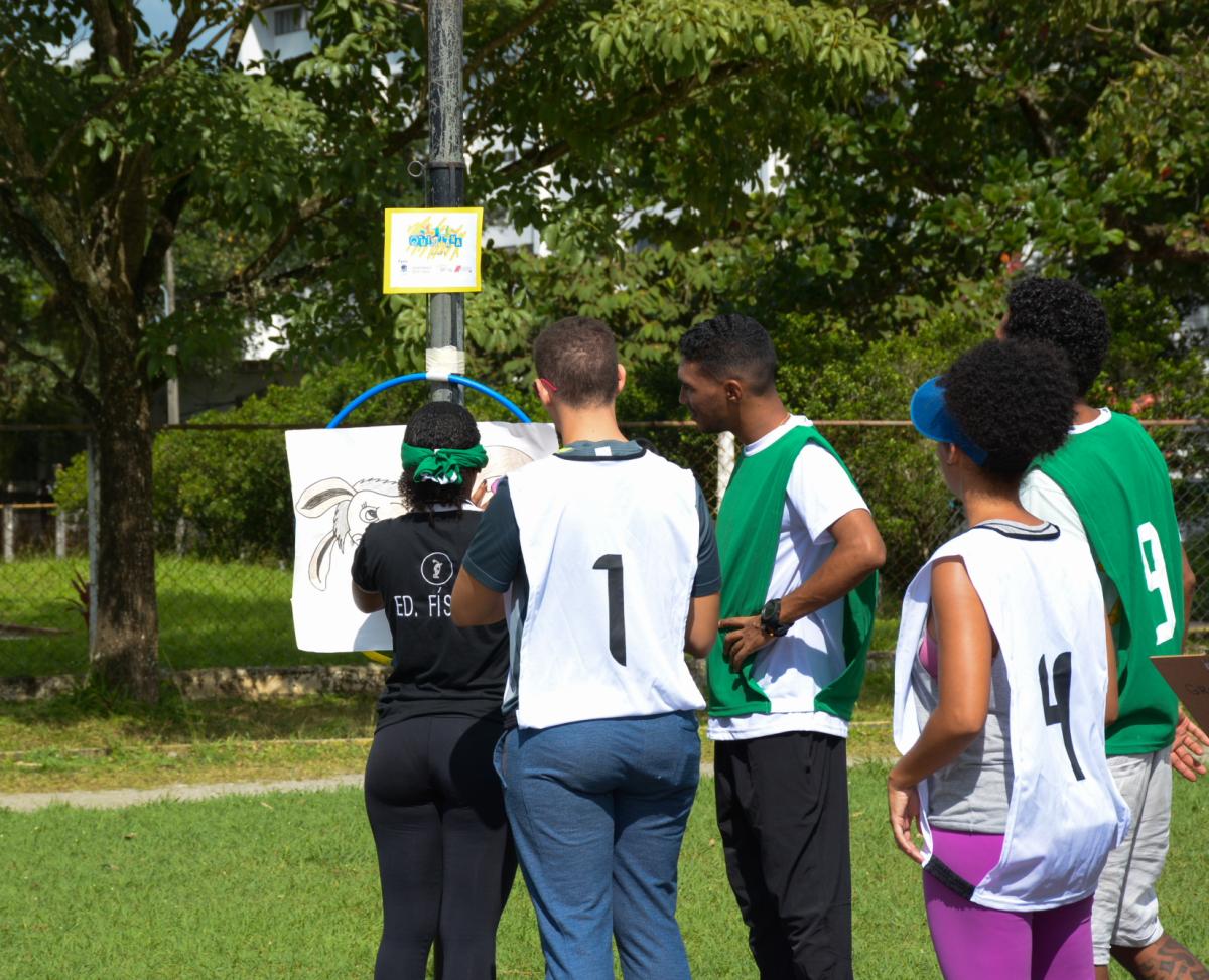 estudantes vendados arremessam bolas em cestas de basquete improvidasas