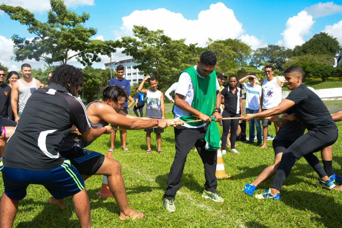 estudantes divididos em grupo puxam corda, em cabo de guerra