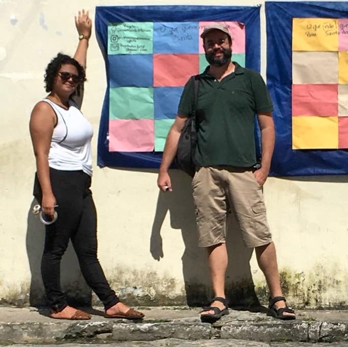 membros do projeto em frente ao painel escrito por moradores