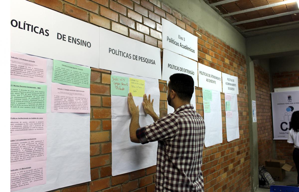 pessoa colando cartazes na parede