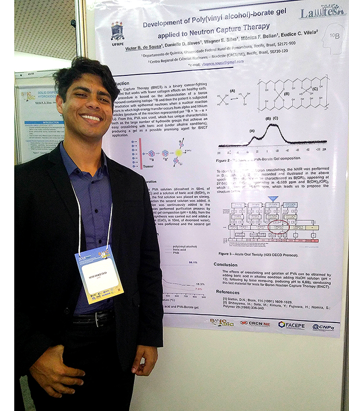 foto do estudante Victor Sousa ao lado do banner e apresentação de seu trabalho